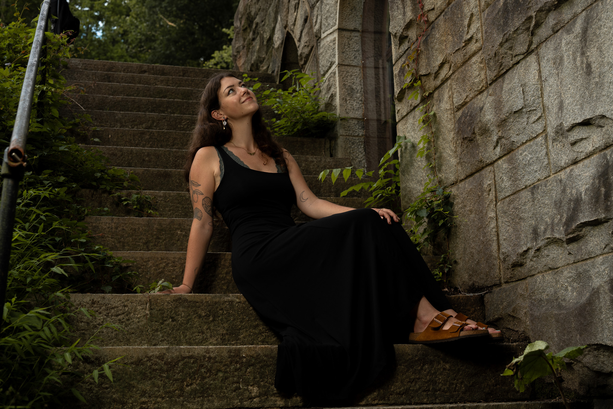Woman in a black dress on mossy stone stairs during a Richmond portrait session